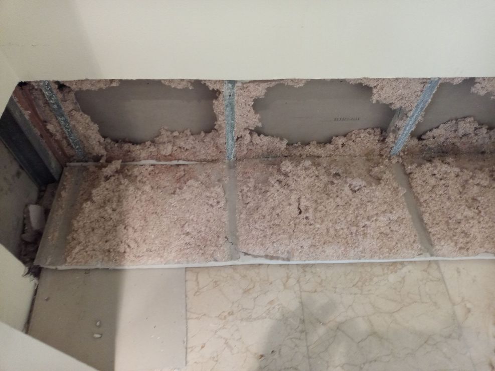 A ceiling with a lot of dust on it and a marble floor.