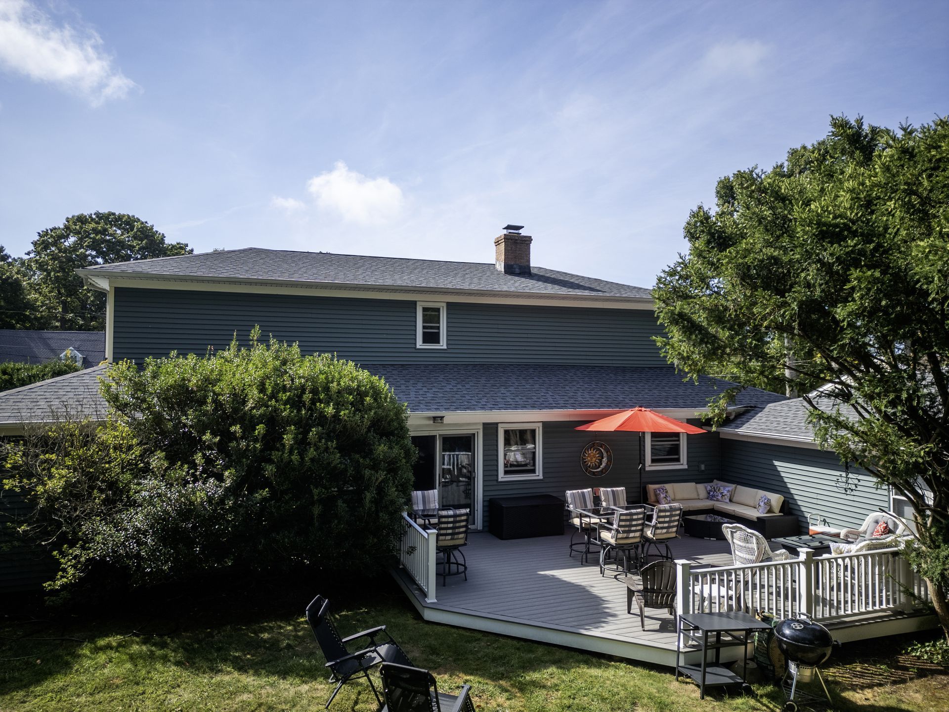 Backyard view featuring a modern composite deck on a residential home.