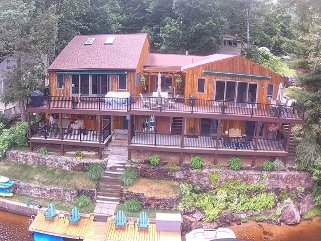 Deck builder wearing a grey t-shirt working on a wooden patio deck outdoors. Deck builder wearing a grey t-shirt working on a wooden patio deck outdoors.