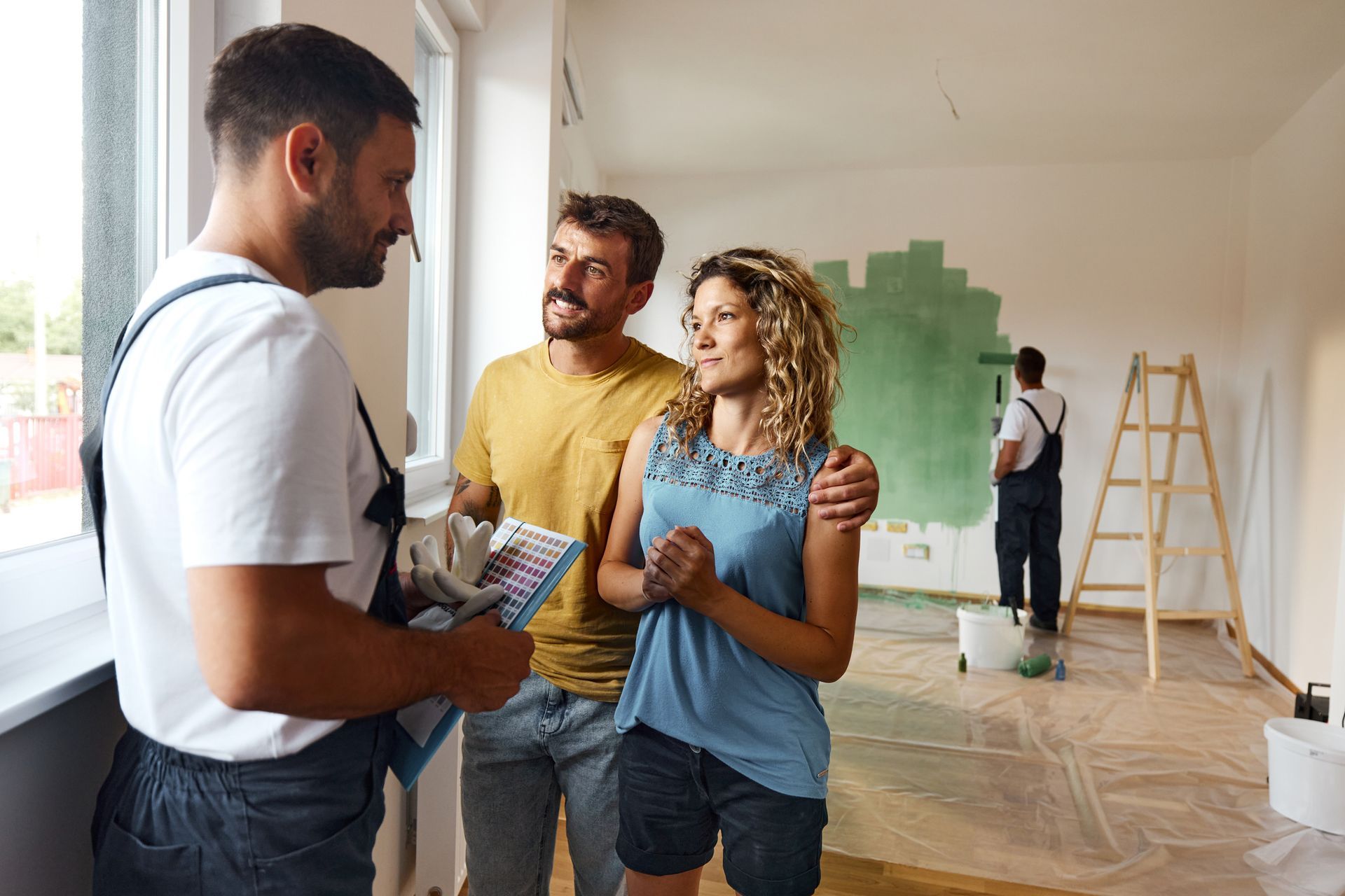 A contractor is talking to a couple during their home renovation process.