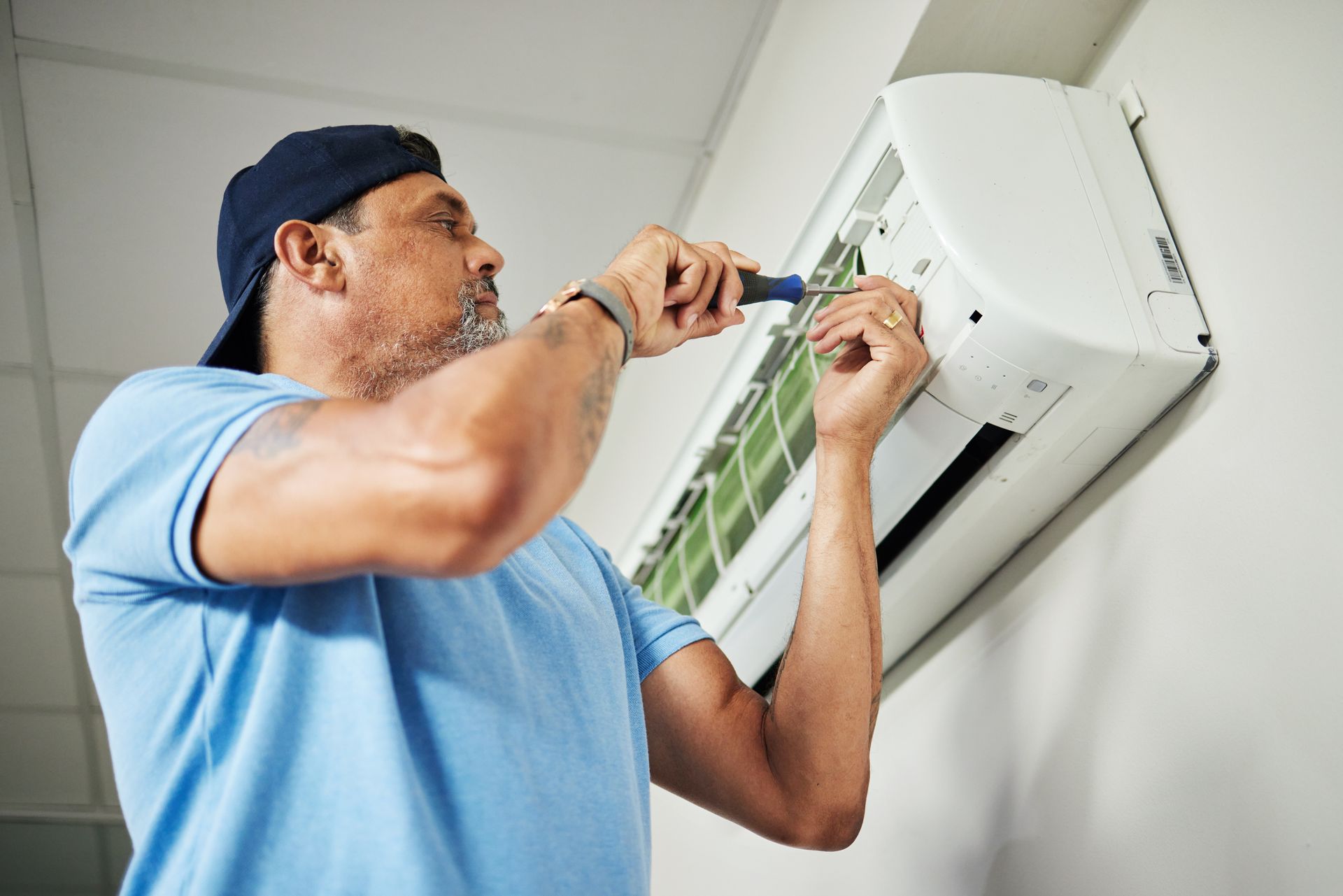 A man is repairing an AC.