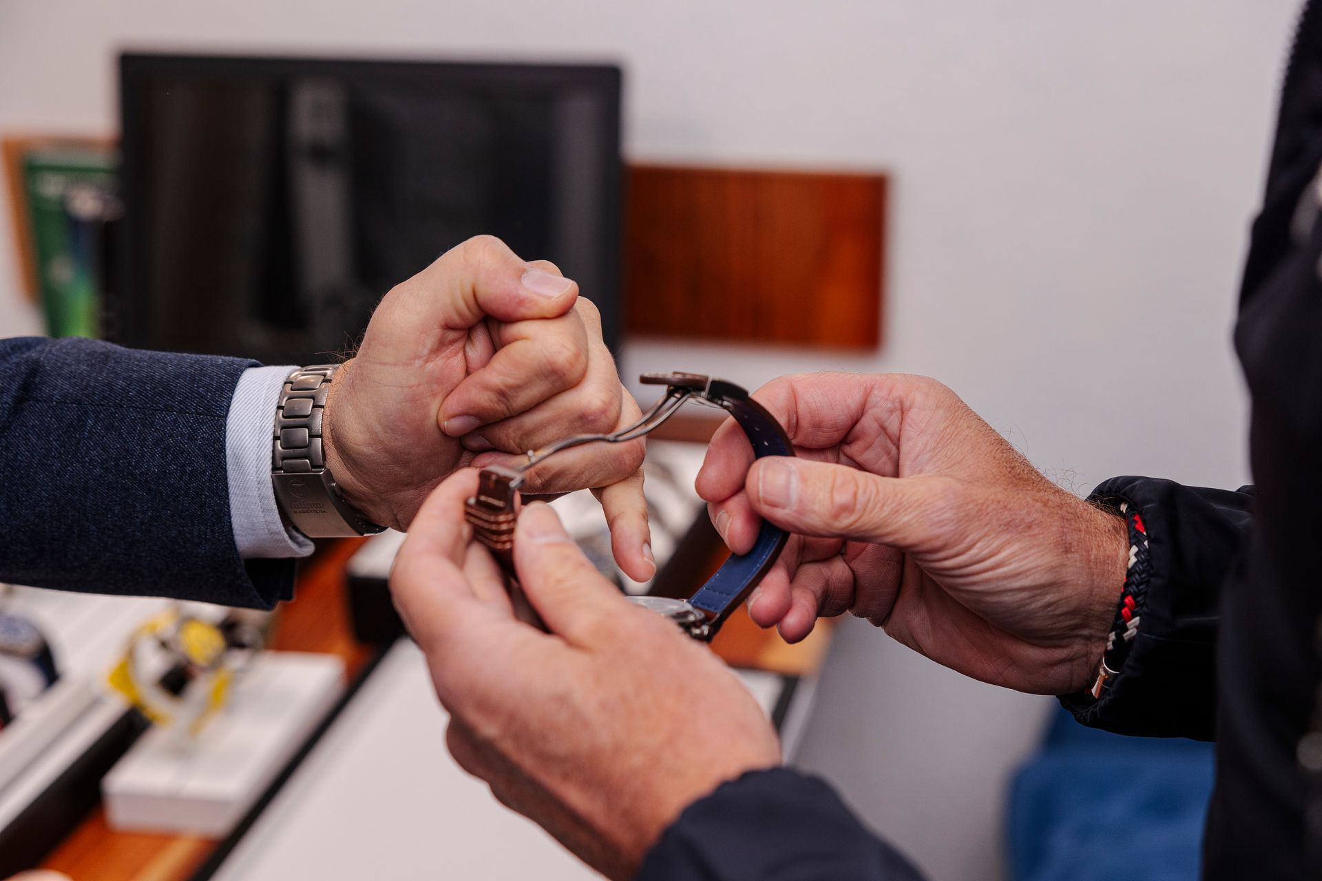 Zwei Männer halten eine Uhr in ihren Händen