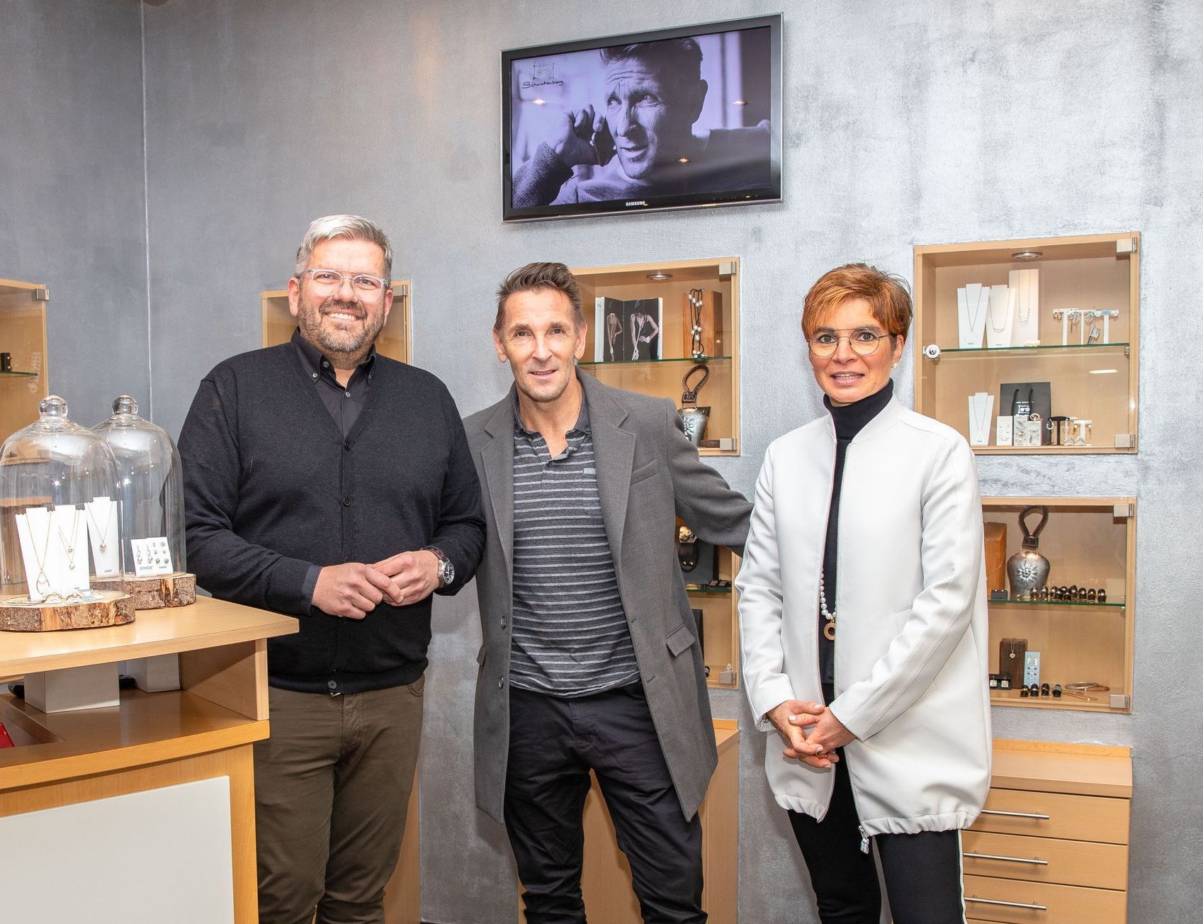 Drei Personen posieren für ein Foto in einem Geschäft