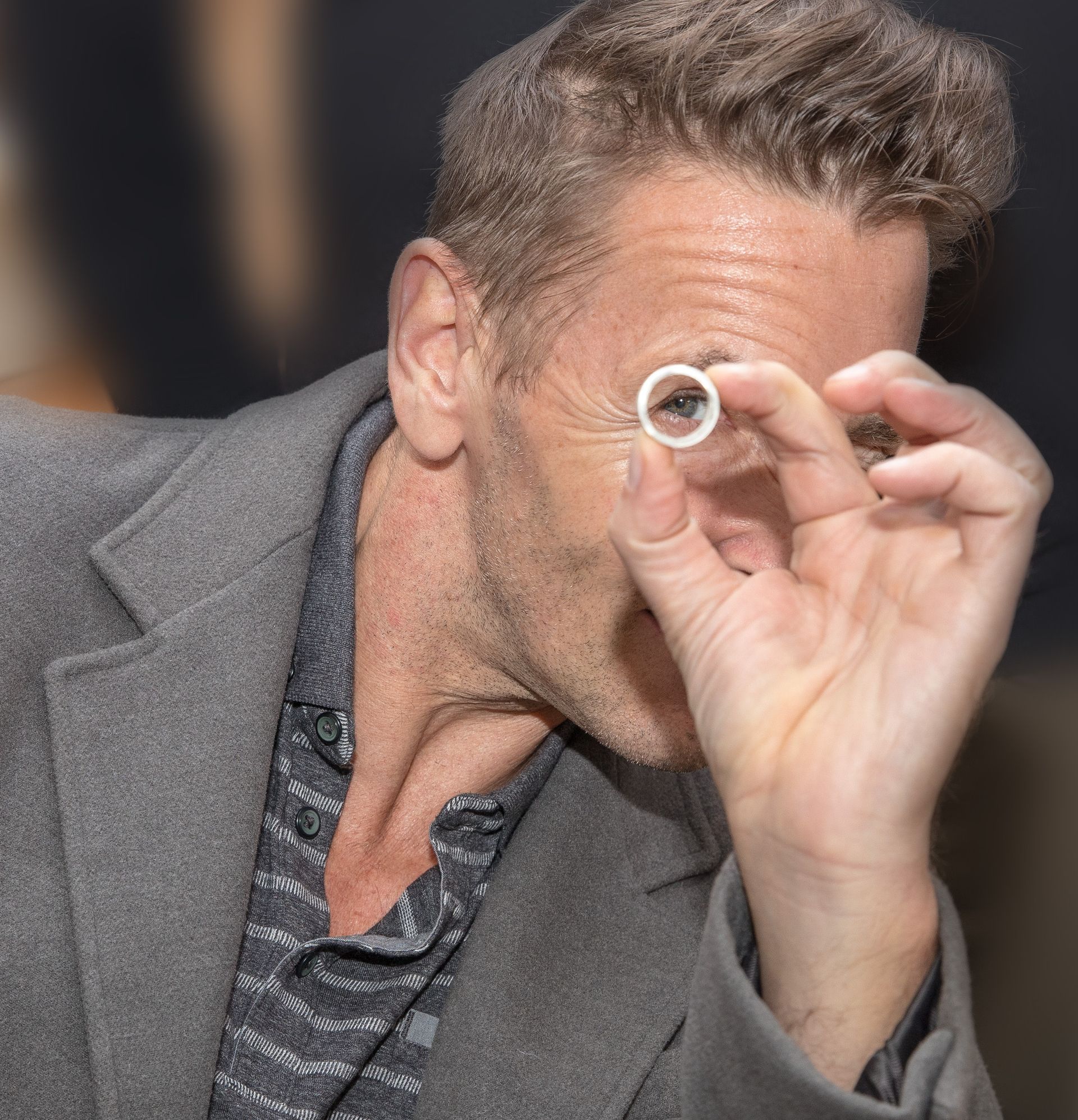 Ein Mann im Anzug schaut durch eine Lupe