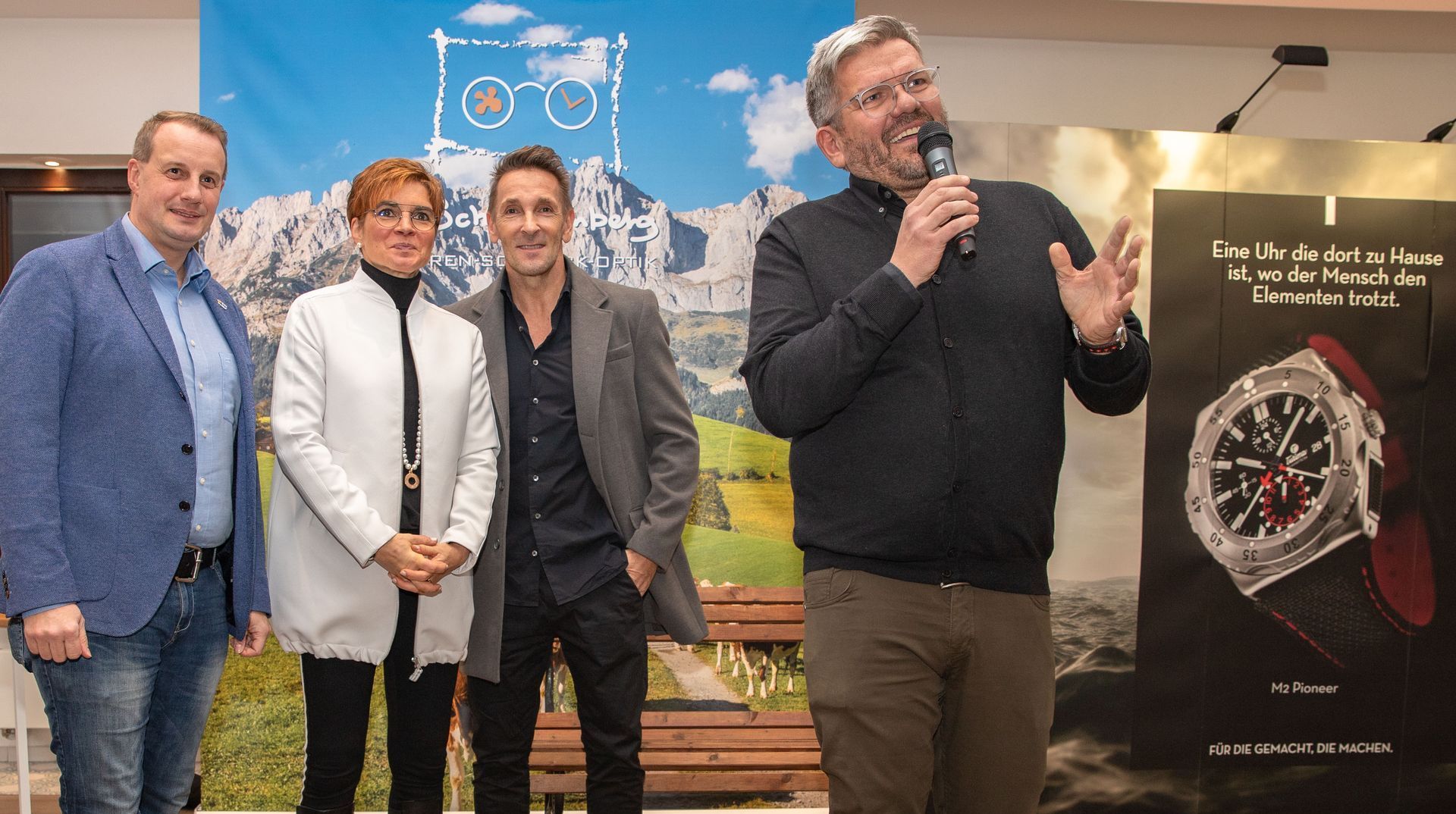 Eine Gruppe von Menschen steht vor einer Uhrenwerbung