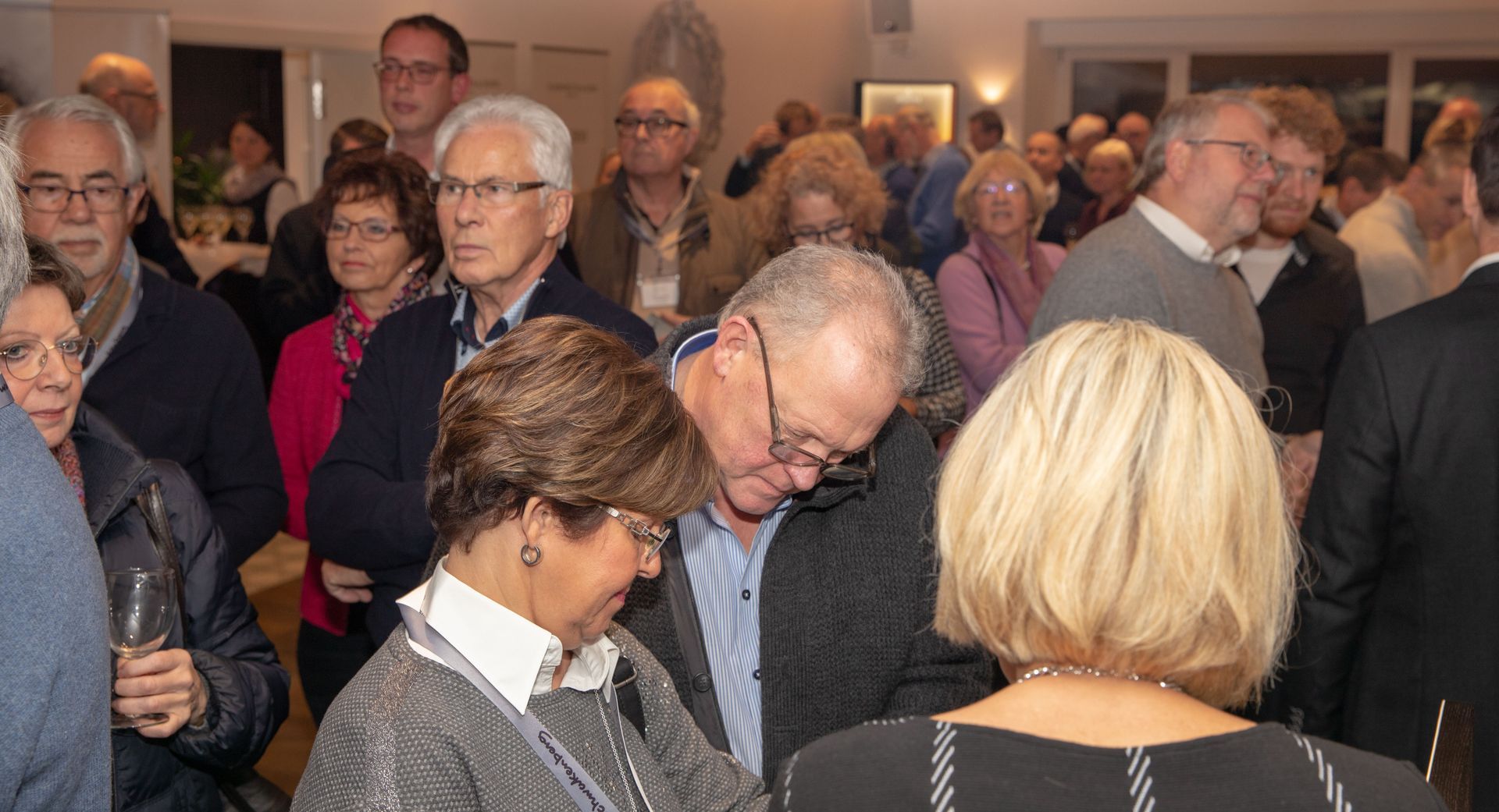 Eine große Gruppe von Menschen versammelt sich in einem Raum
