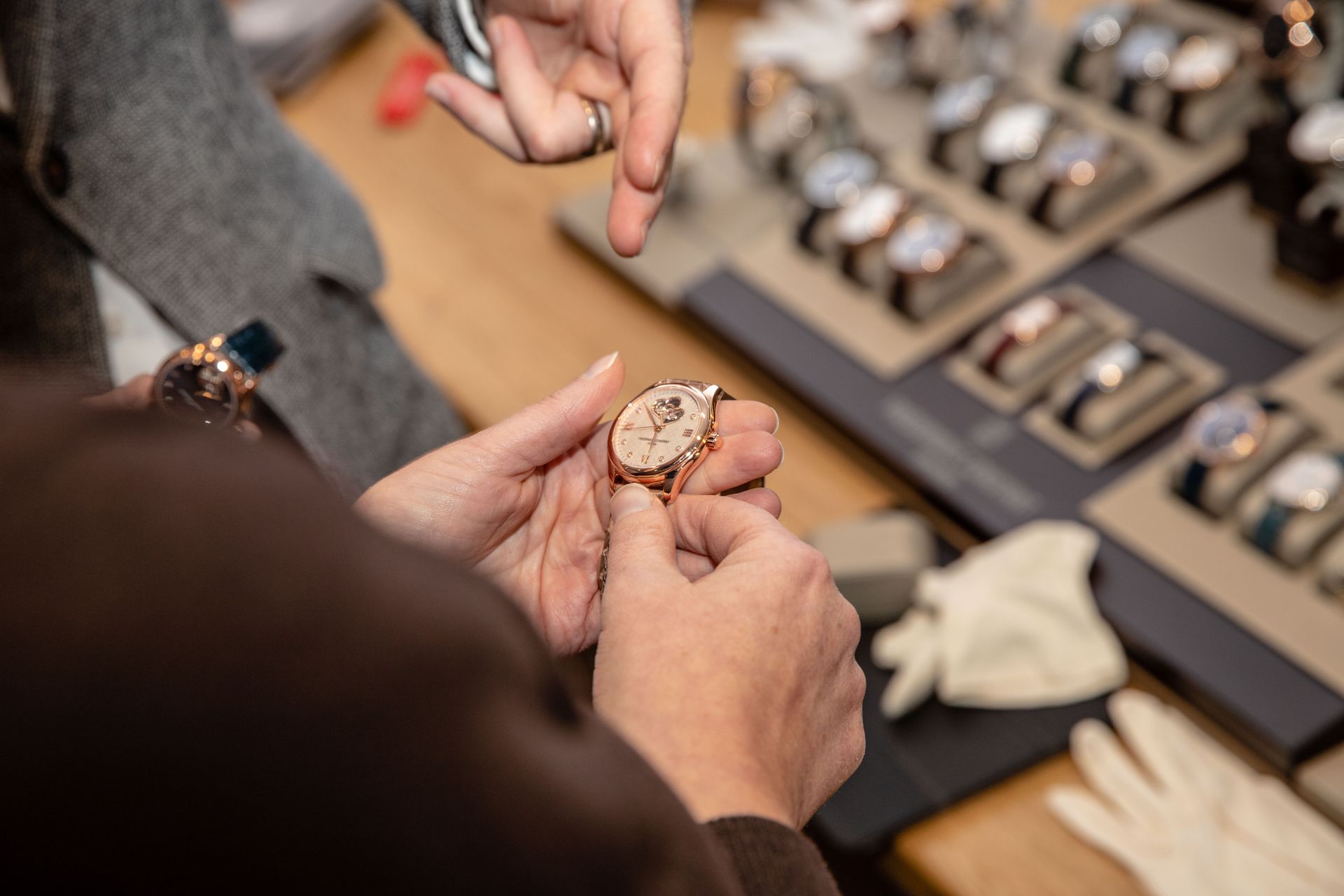 Eine Person hält eine Uhr in der Hand und zeigt darauf