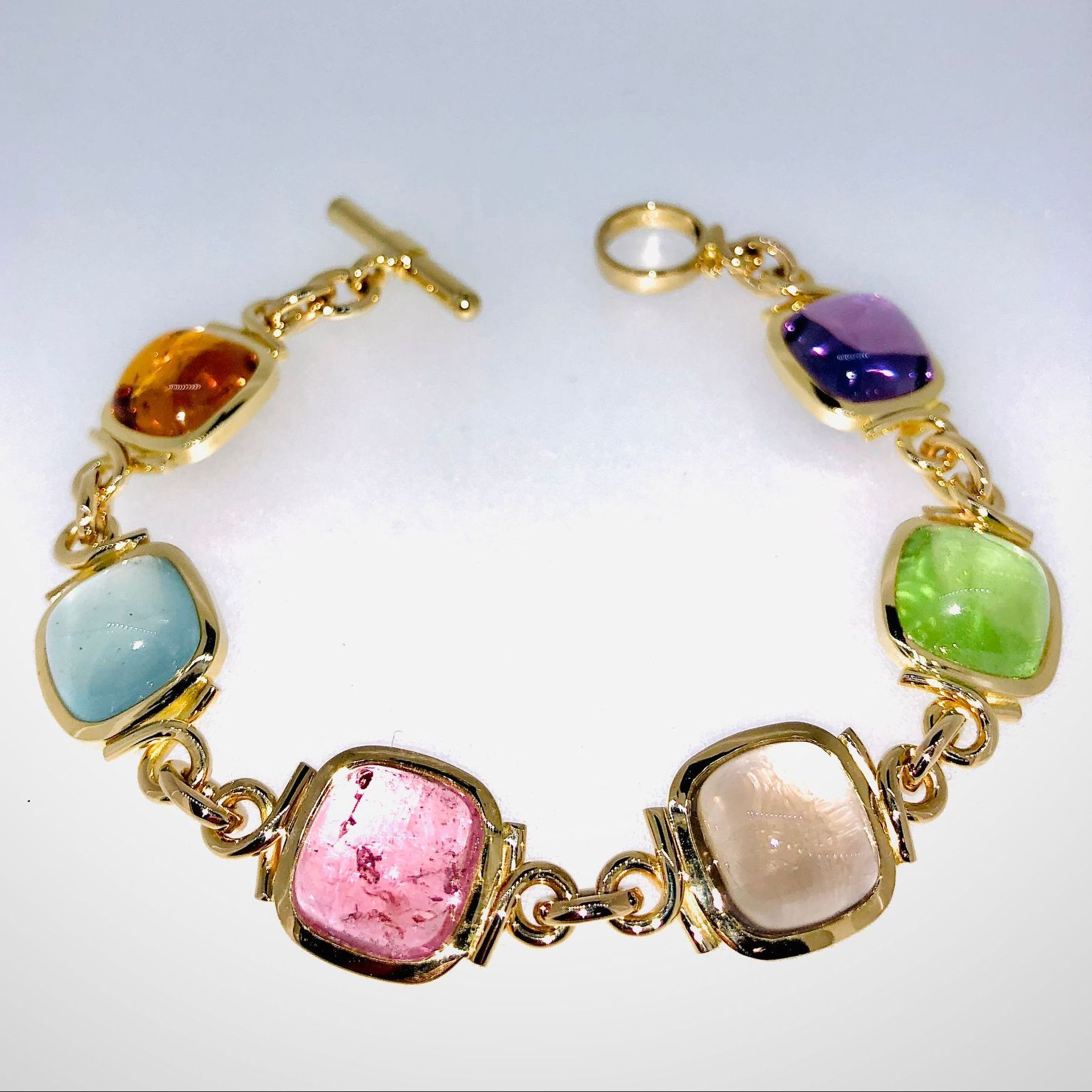 Ein goldenes Armband mit bunten Steinen darauf