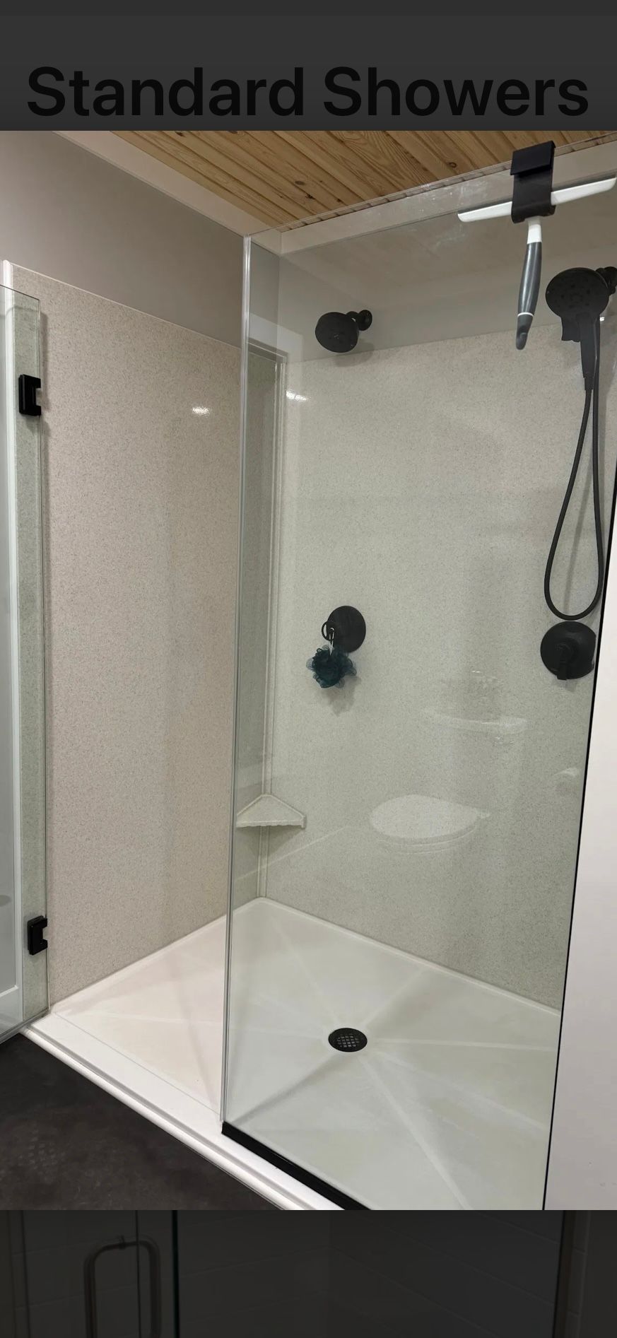 A modern shower enclosure with glass doors, a white base, and black fixtures.