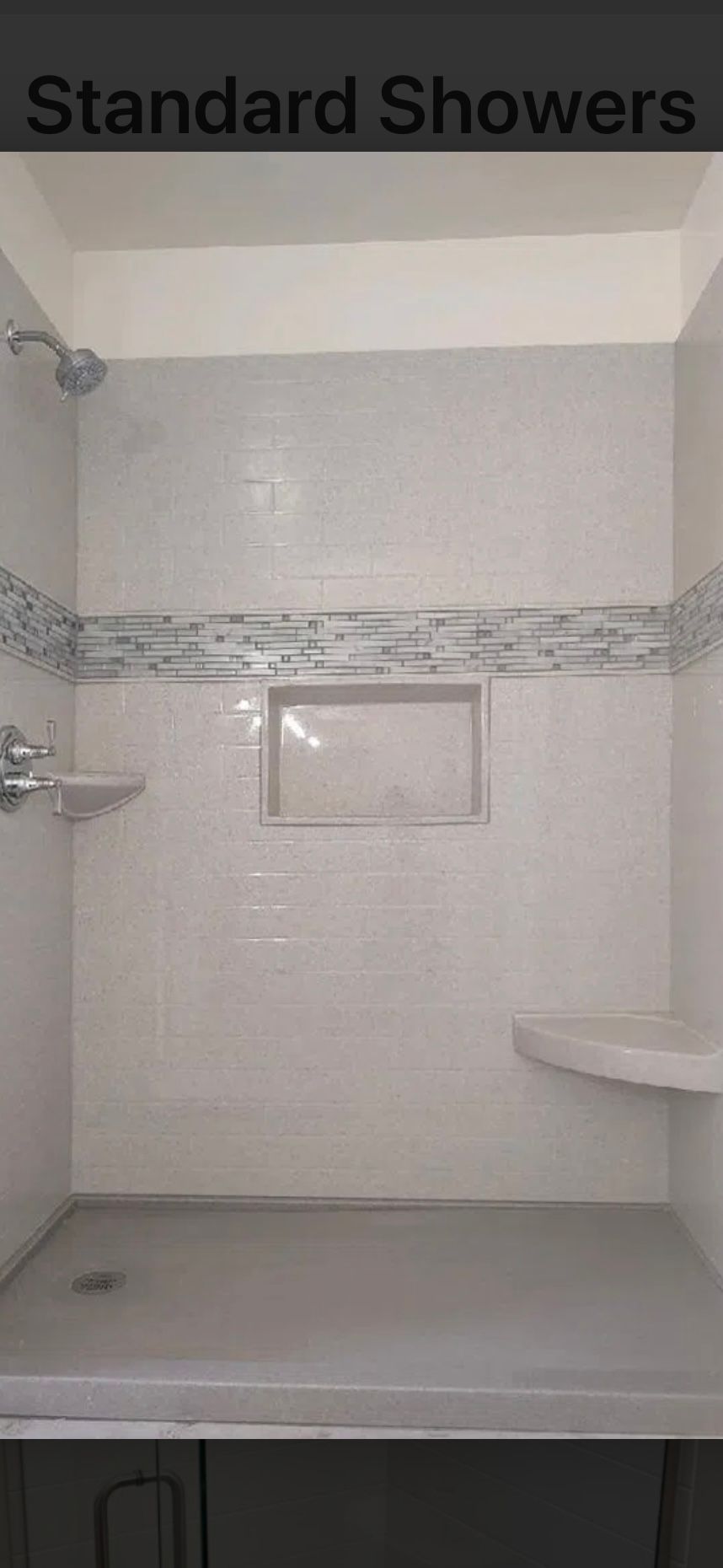 White tiled standard shower with built-in bench, niche, and mosaic accent strip.