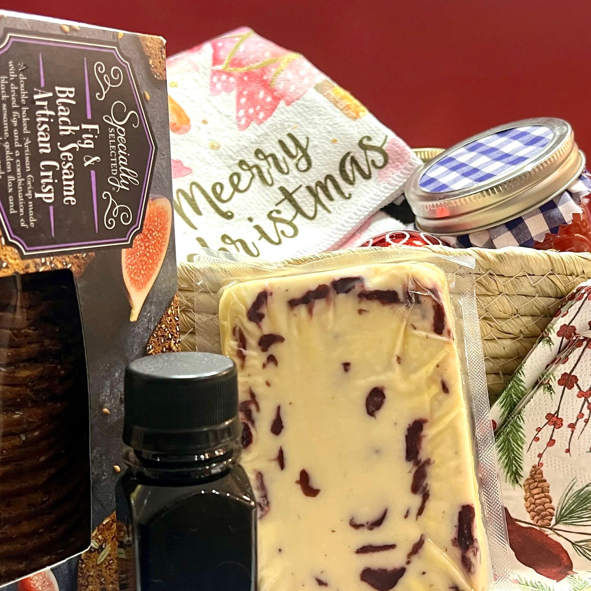 A bottle of merry christmas is sitting next to a piece of cheese