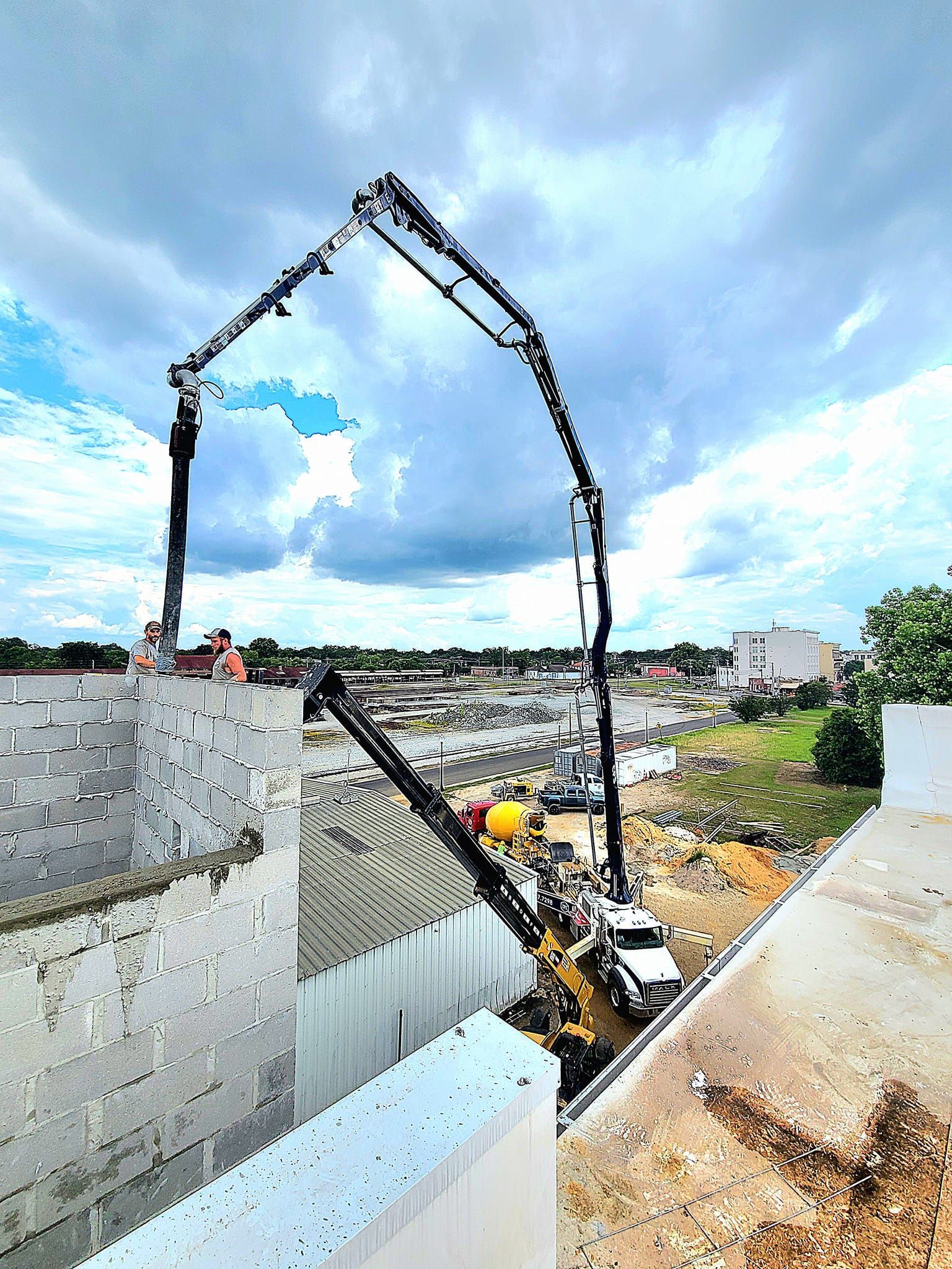 A concrete pump is being used to pour concrete into a building.