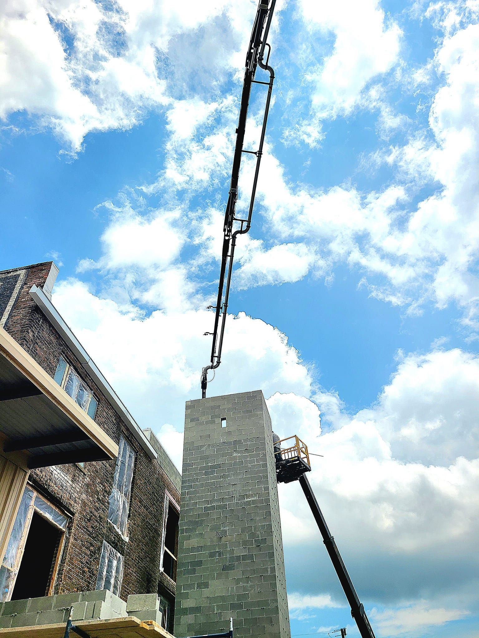 A crane is pumping concrete into a building under construction.