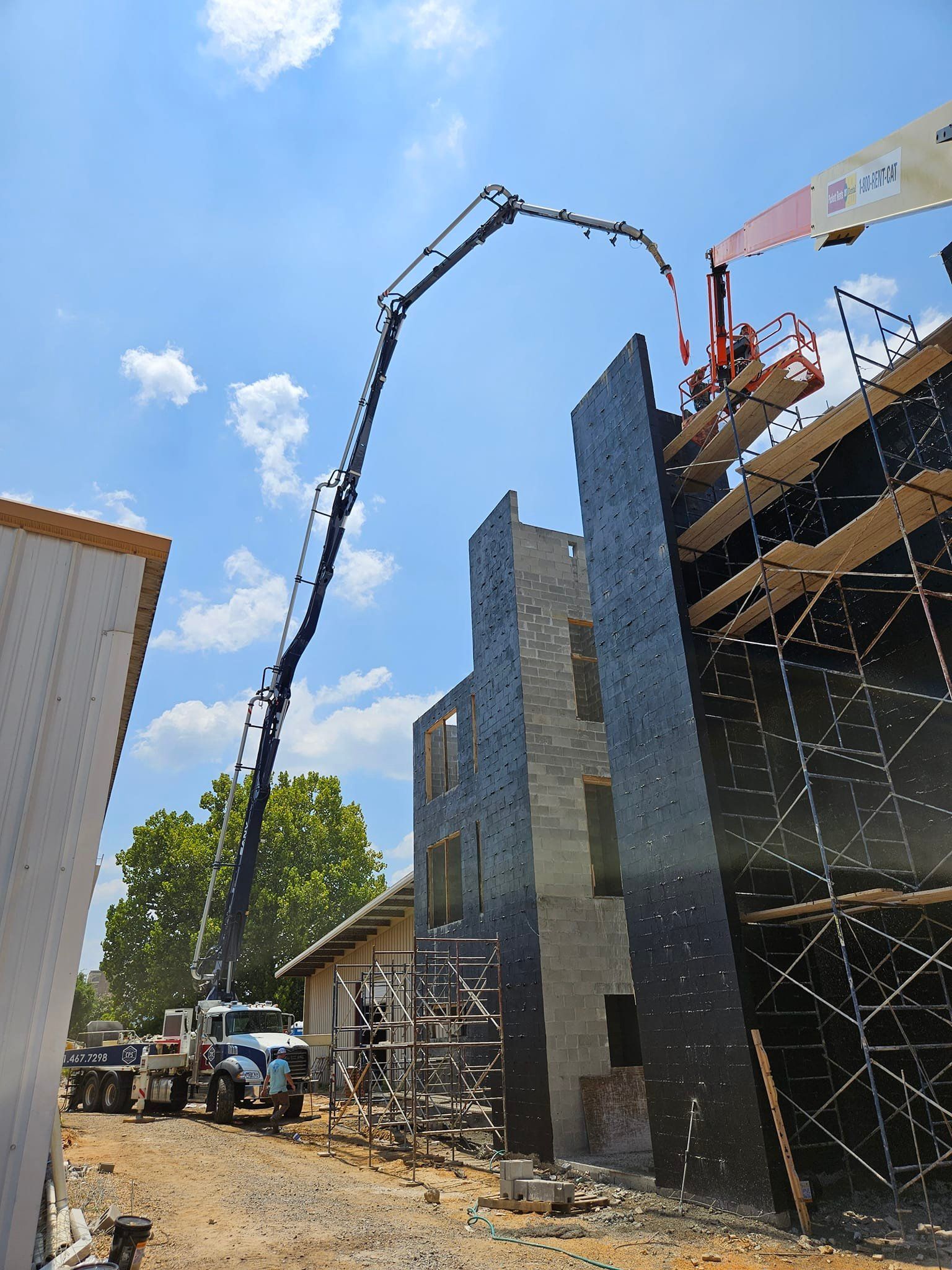A crane is pouring concrete into a building under construction
