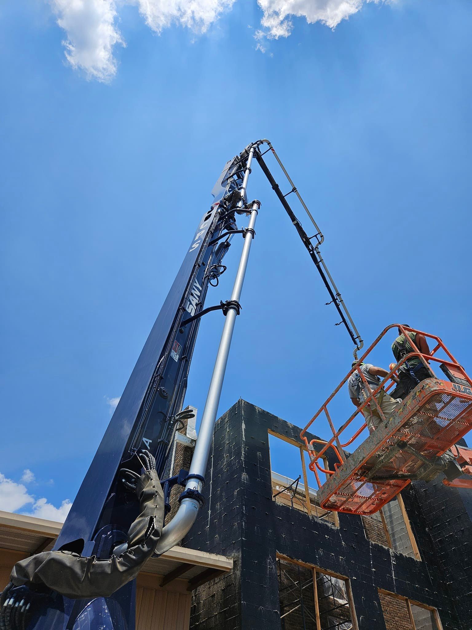 A crane is being used to pump concrete into a building