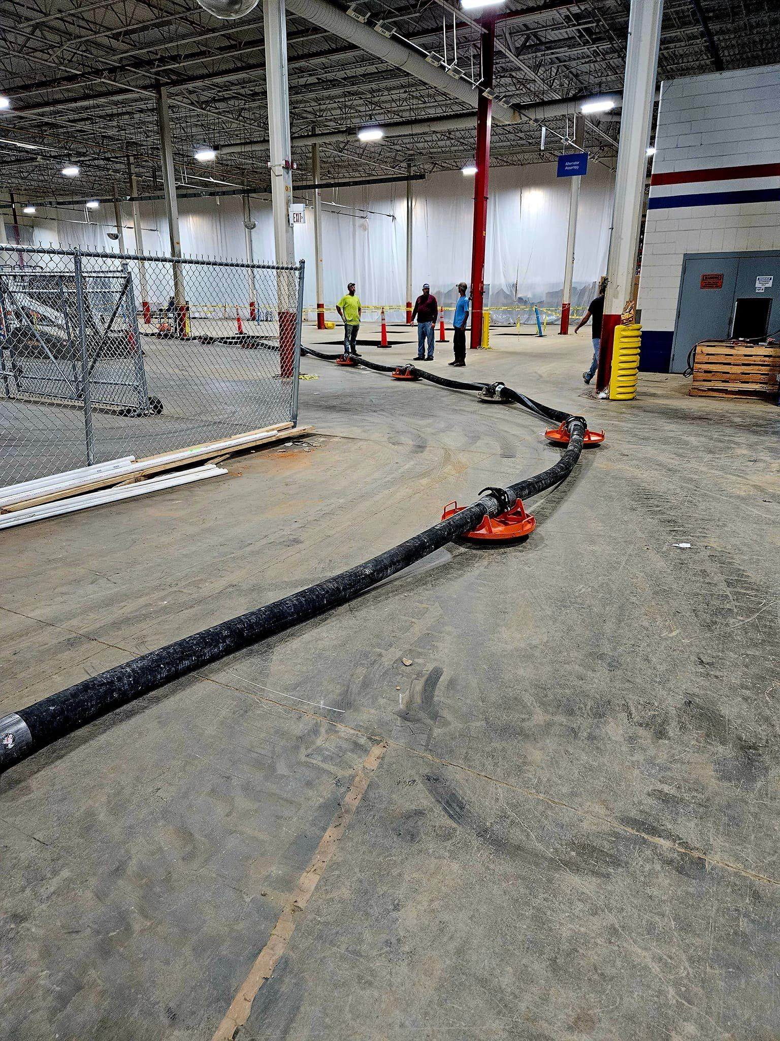 A rc car is driving down a track in a warehouse.