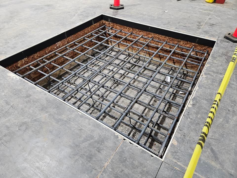 A large hole in the ground with a yellow caution tape around it