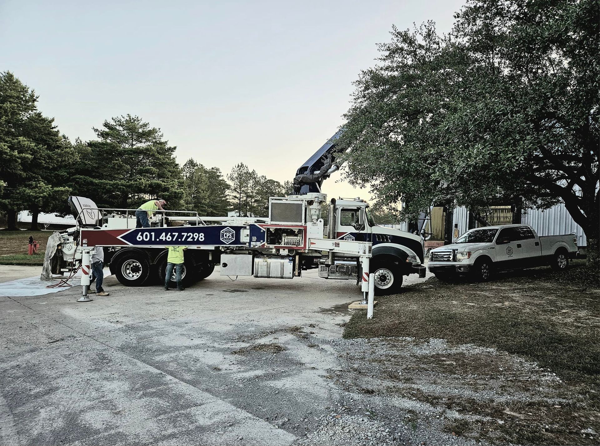 A truck with a crane on the back is parked in a parking lot