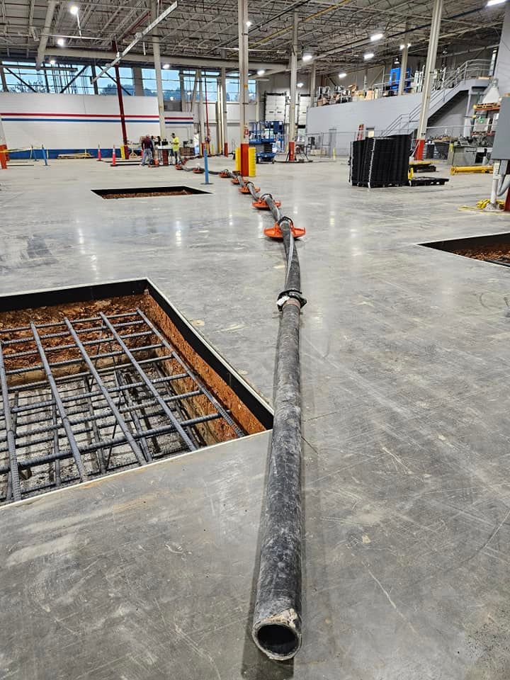 A pipe is laying on the floor of a building under construction.