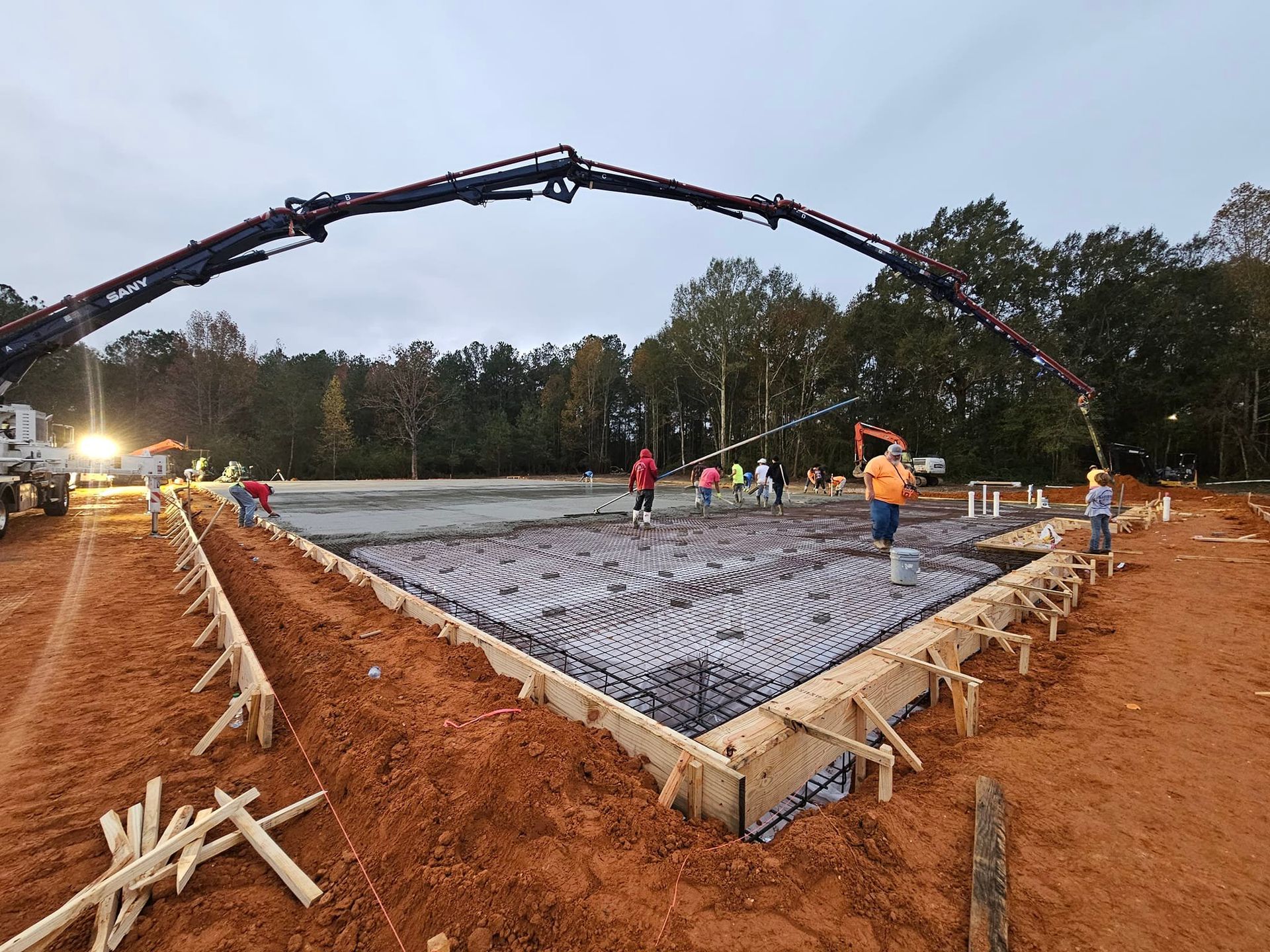 A group of construction workers are working on a concrete base.