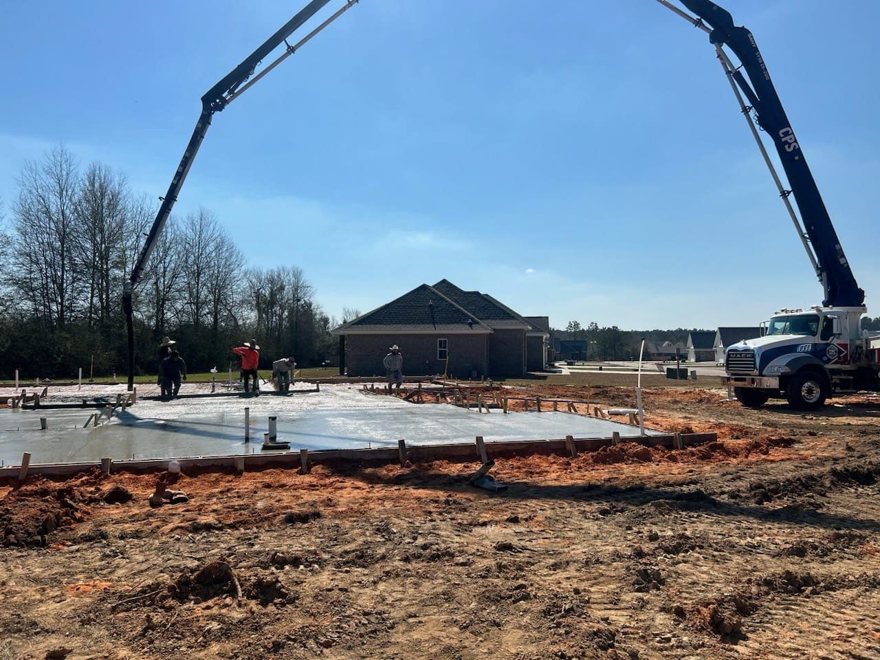 A concrete pump is being used to pour concrete on a construction site.
