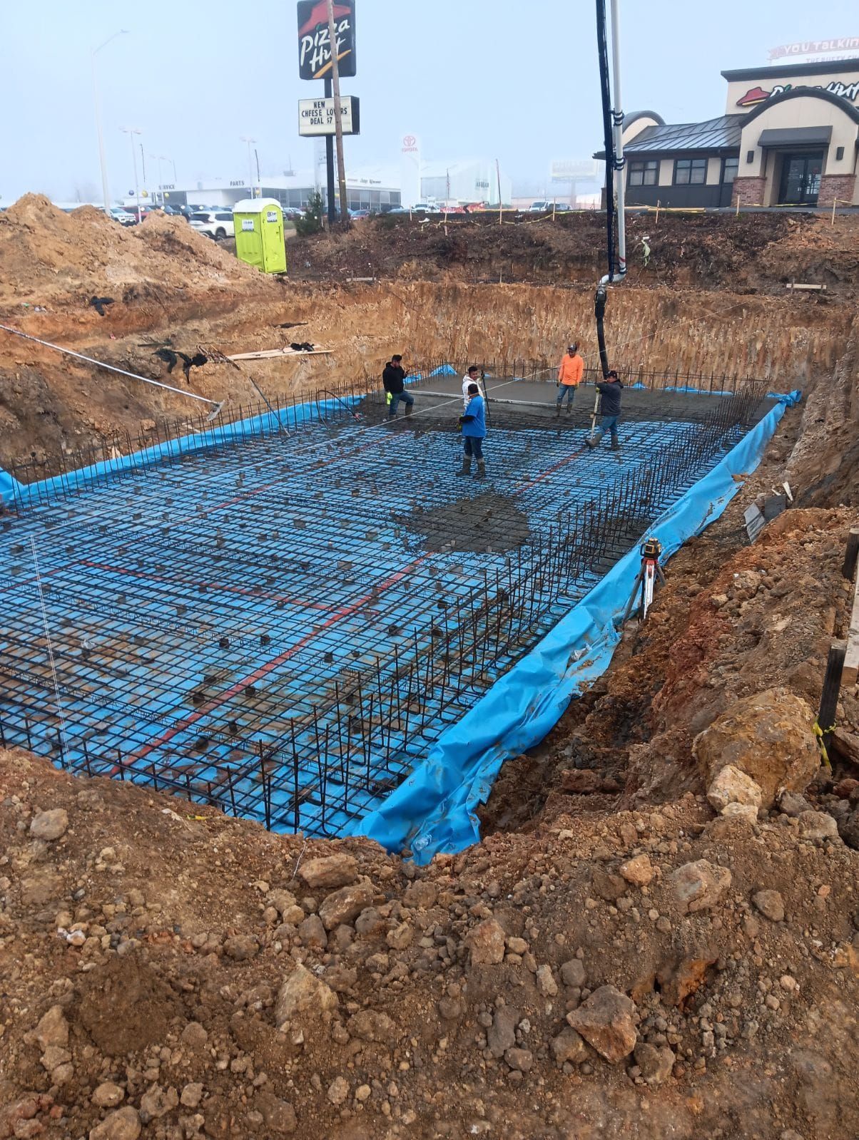 A large concrete slab is being poured on a construction site.