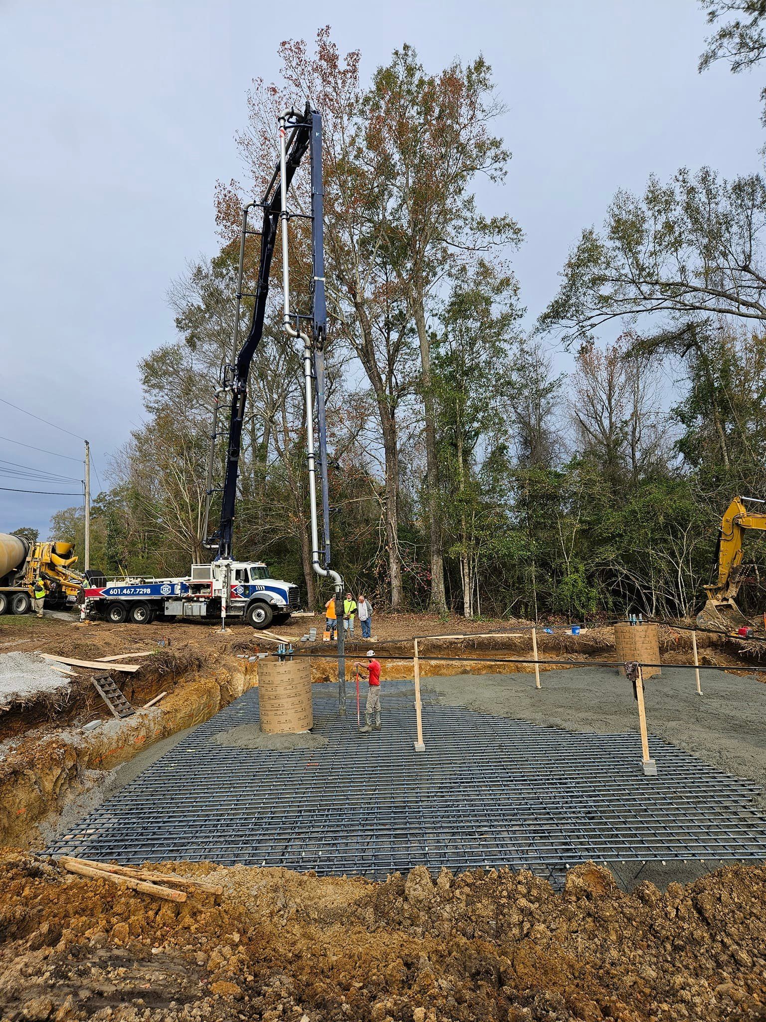 A concrete pump is being used to pour concrete on a construction site.