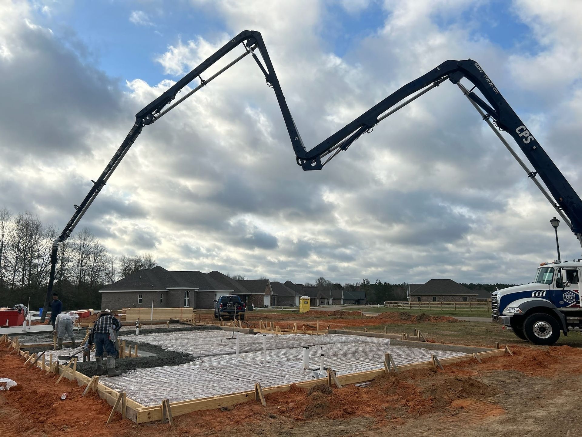 A concrete pump is being used to pour concrete on a construction site.