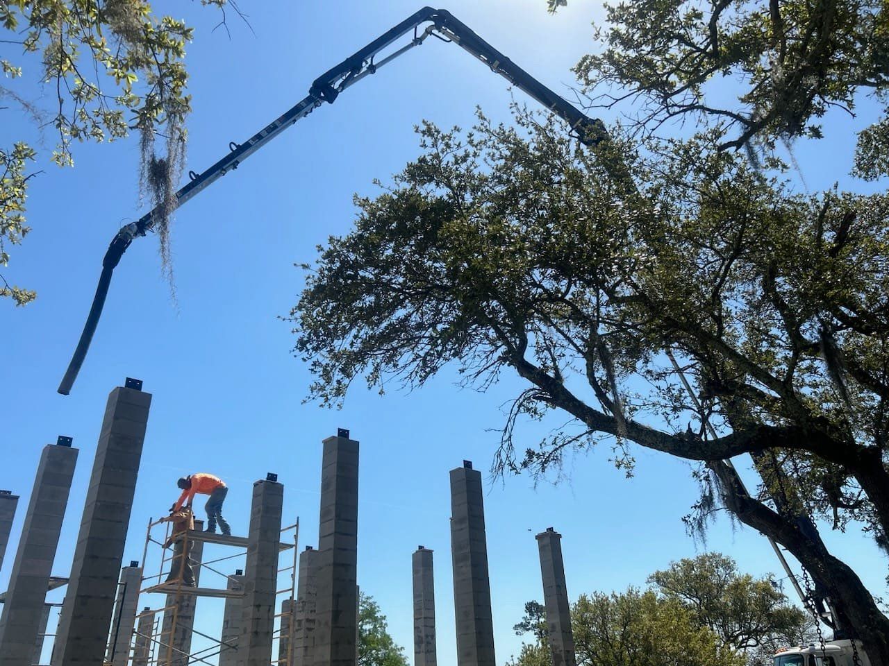 A concrete pump is being used to pour concrete into a building