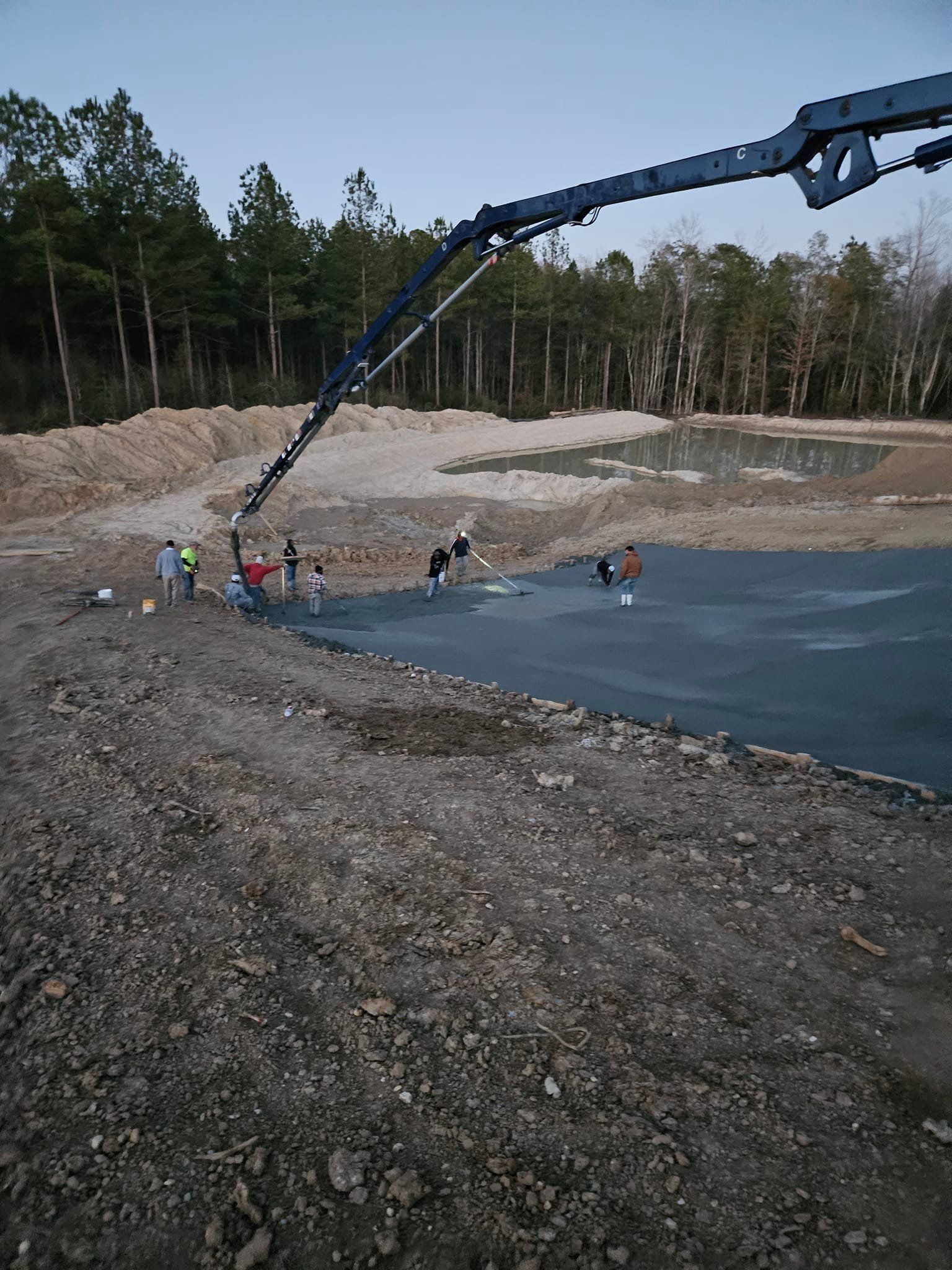 A group of people are standing in front of a large body of water.