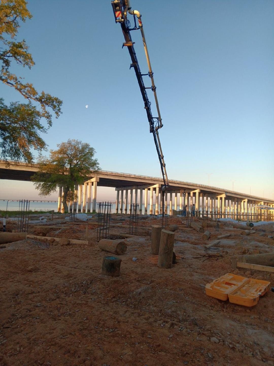 A construction site with a bridge in the background