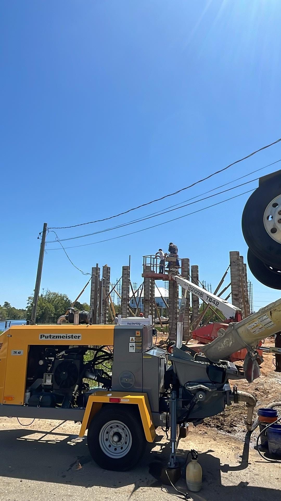 A concrete pump is being used to pour concrete on a construction site.