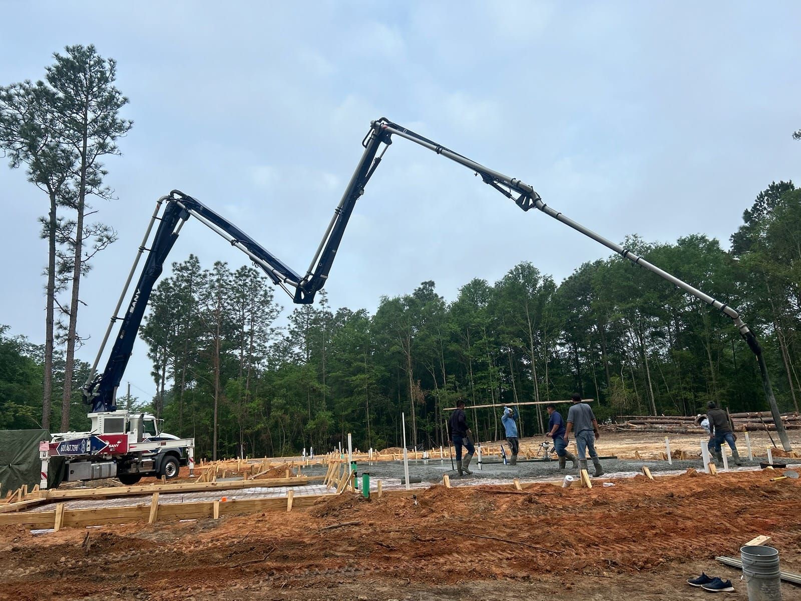 A concrete pump is being used to pour concrete on a construction site.