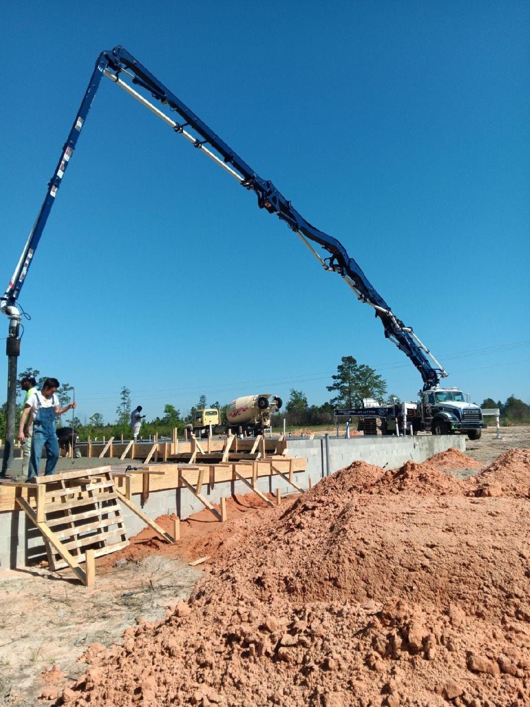A concrete pump is being used to pour concrete on a construction site.
