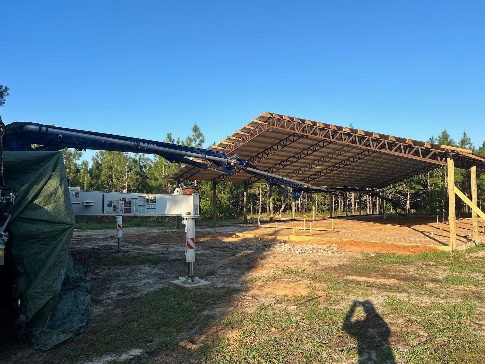 A crane is being used to build a building in a field.