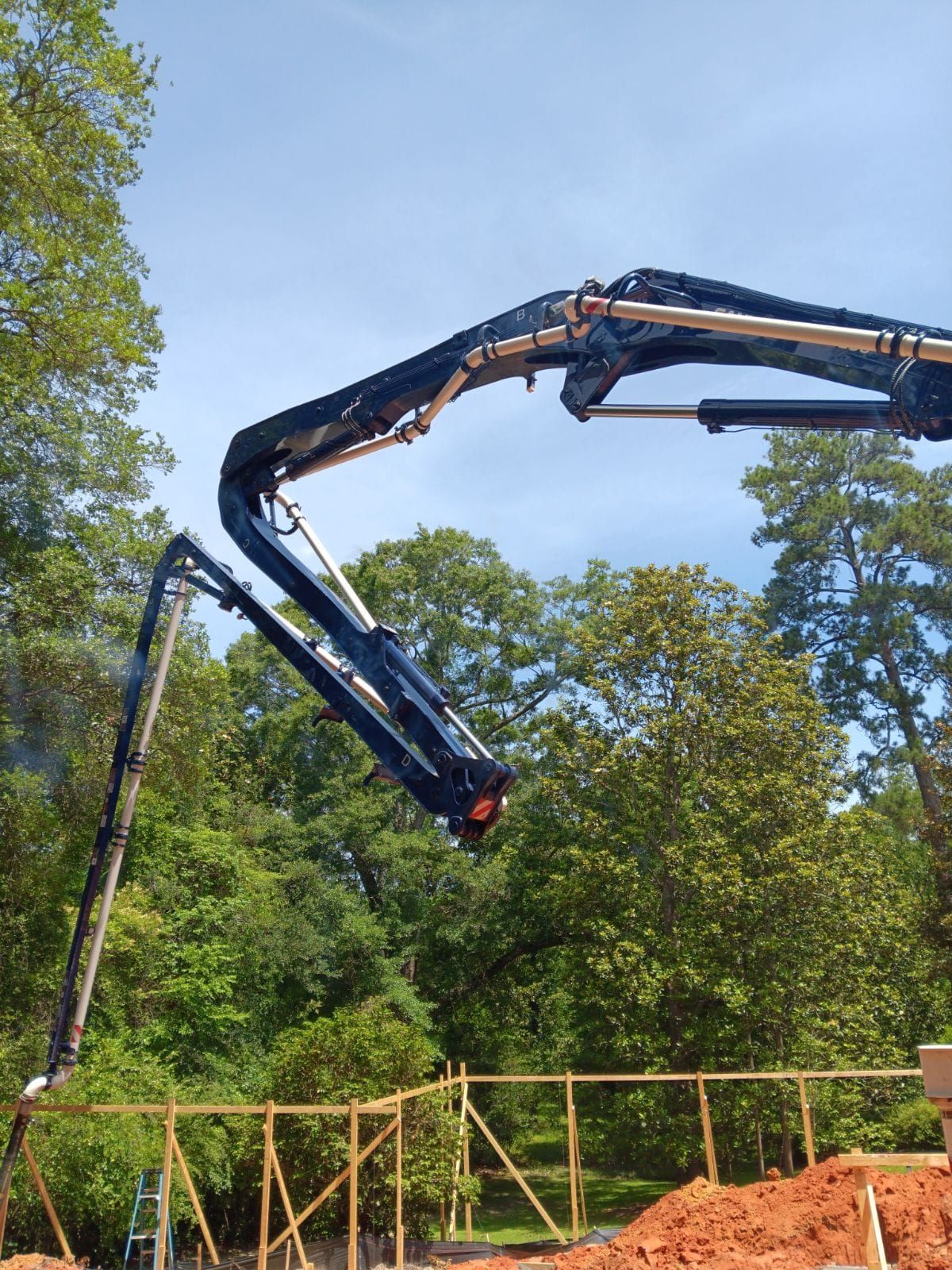 A concrete pump is being used to pour concrete on a construction site.