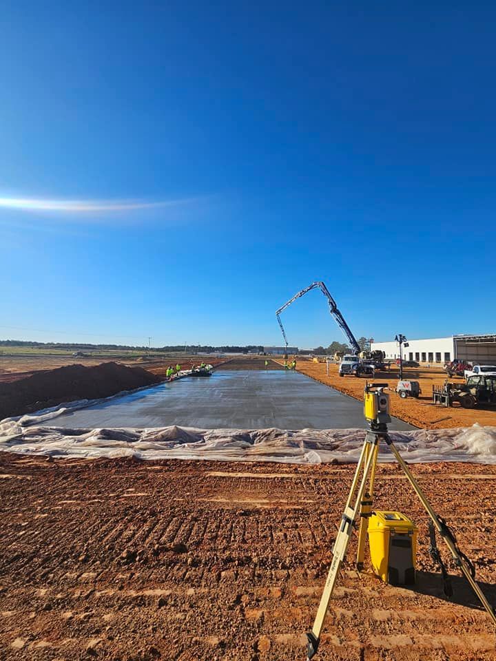 A construction site with a lot of dirt and a building in the background.