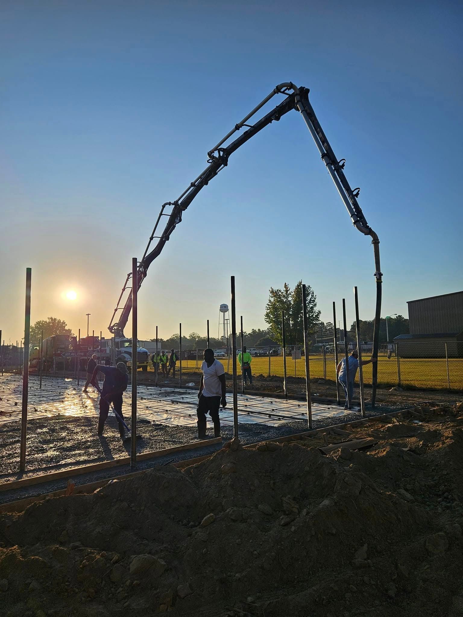 A concrete pump is being used to pour concrete into a field.