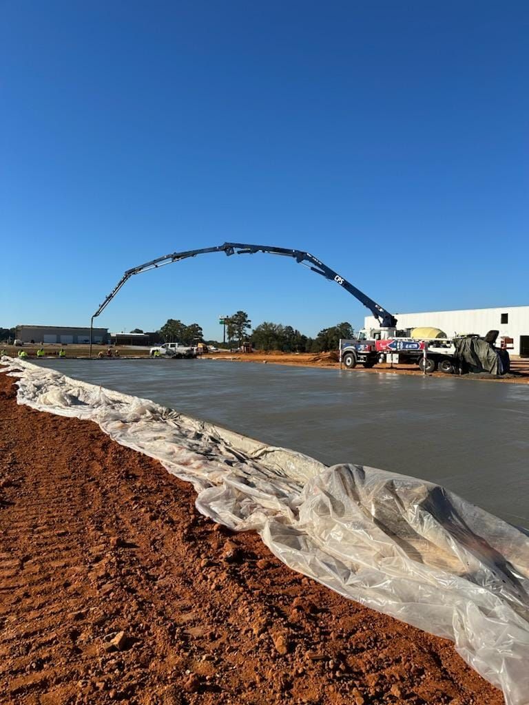 A concrete pump is being used to pour concrete on a construction site.