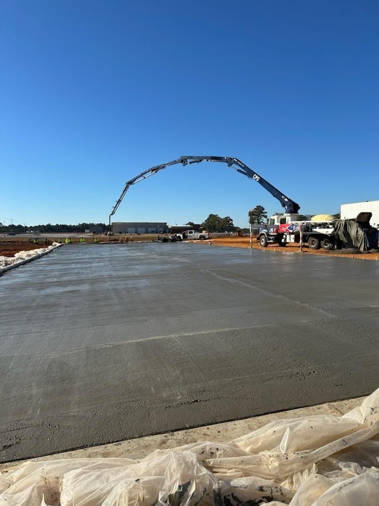 A crane is pumping concrete into a concrete floor.