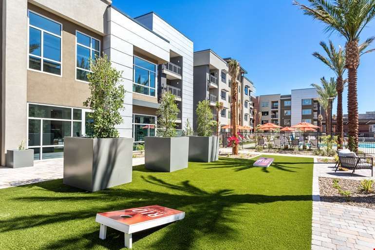 A large building with a lot of windows and a lawn in front of it.