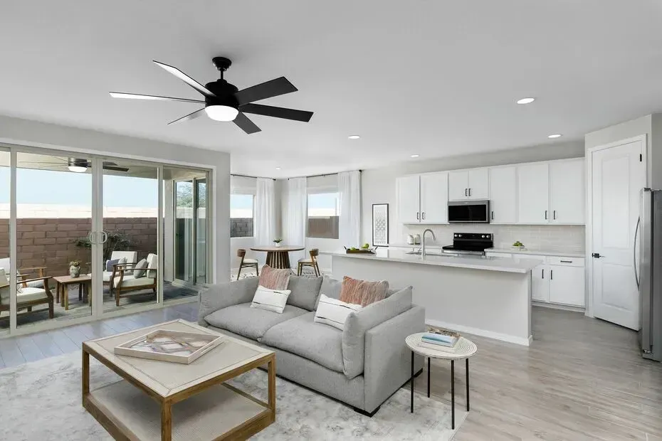 Open-concept living space with gray sofa, kitchen, and patio access.