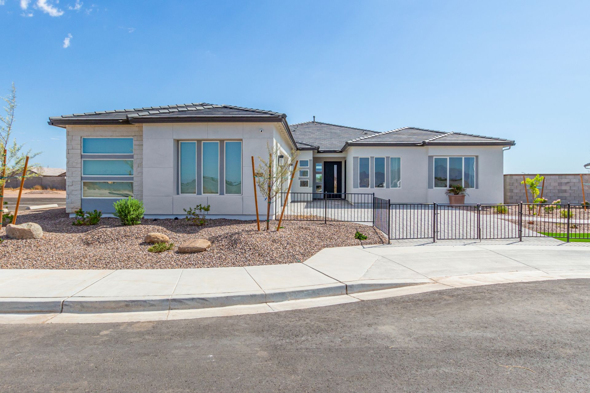 A large white house with a lot of windows is sitting on the side of a road.
