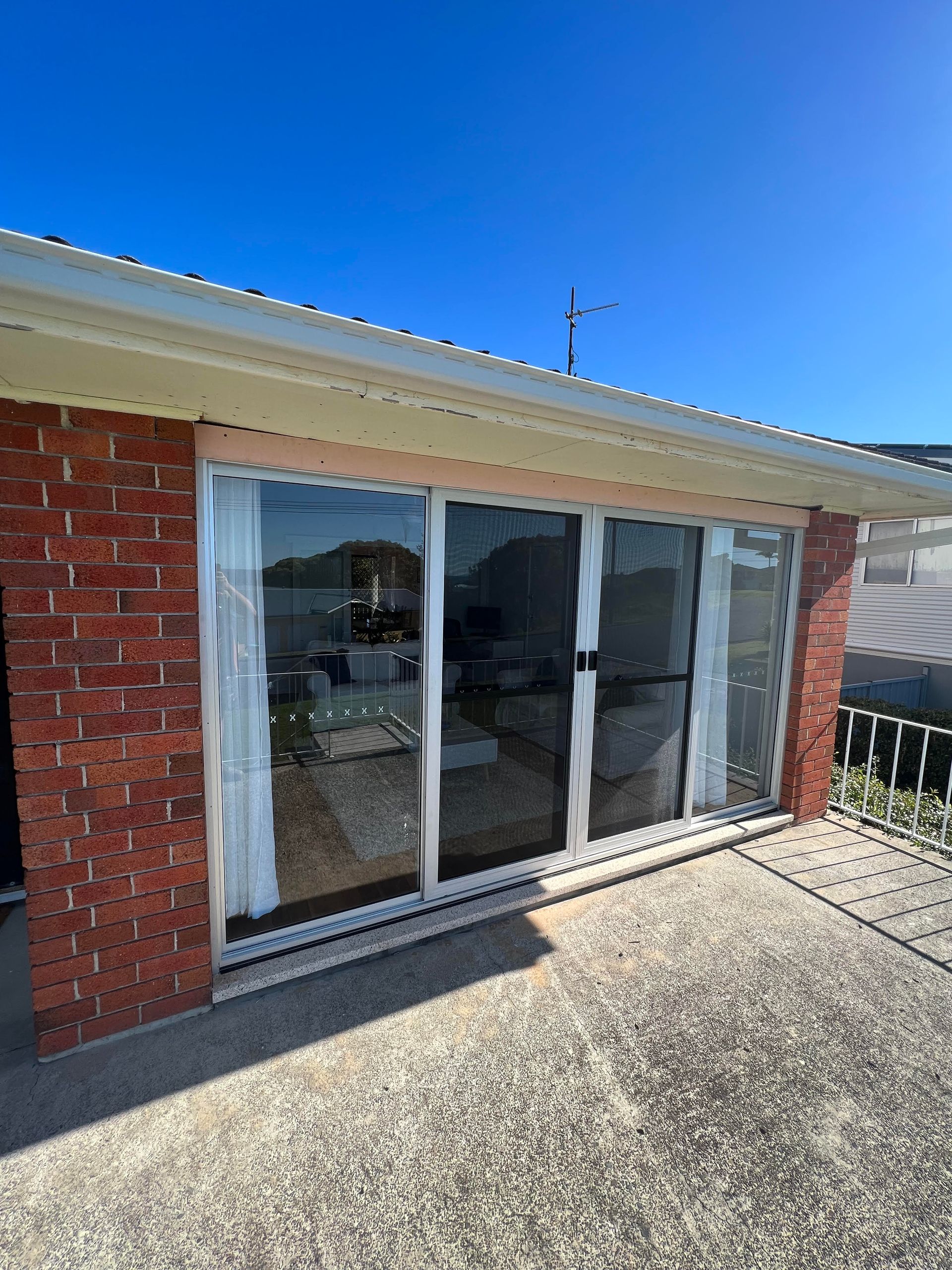 An Aluminium Sliding Door on A Brick House— Glass 24/7 In Taree, NSW