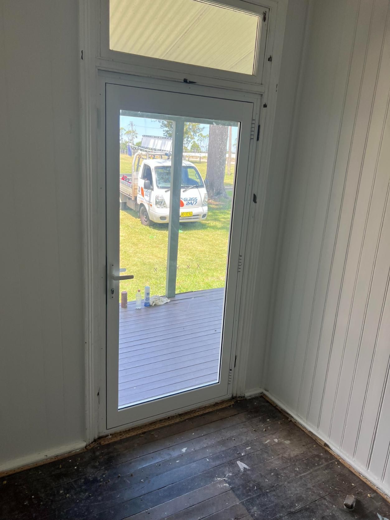 There Is A Truck Parked In The Grass Behind The Door — Glass 24/7 In Taree, NSW