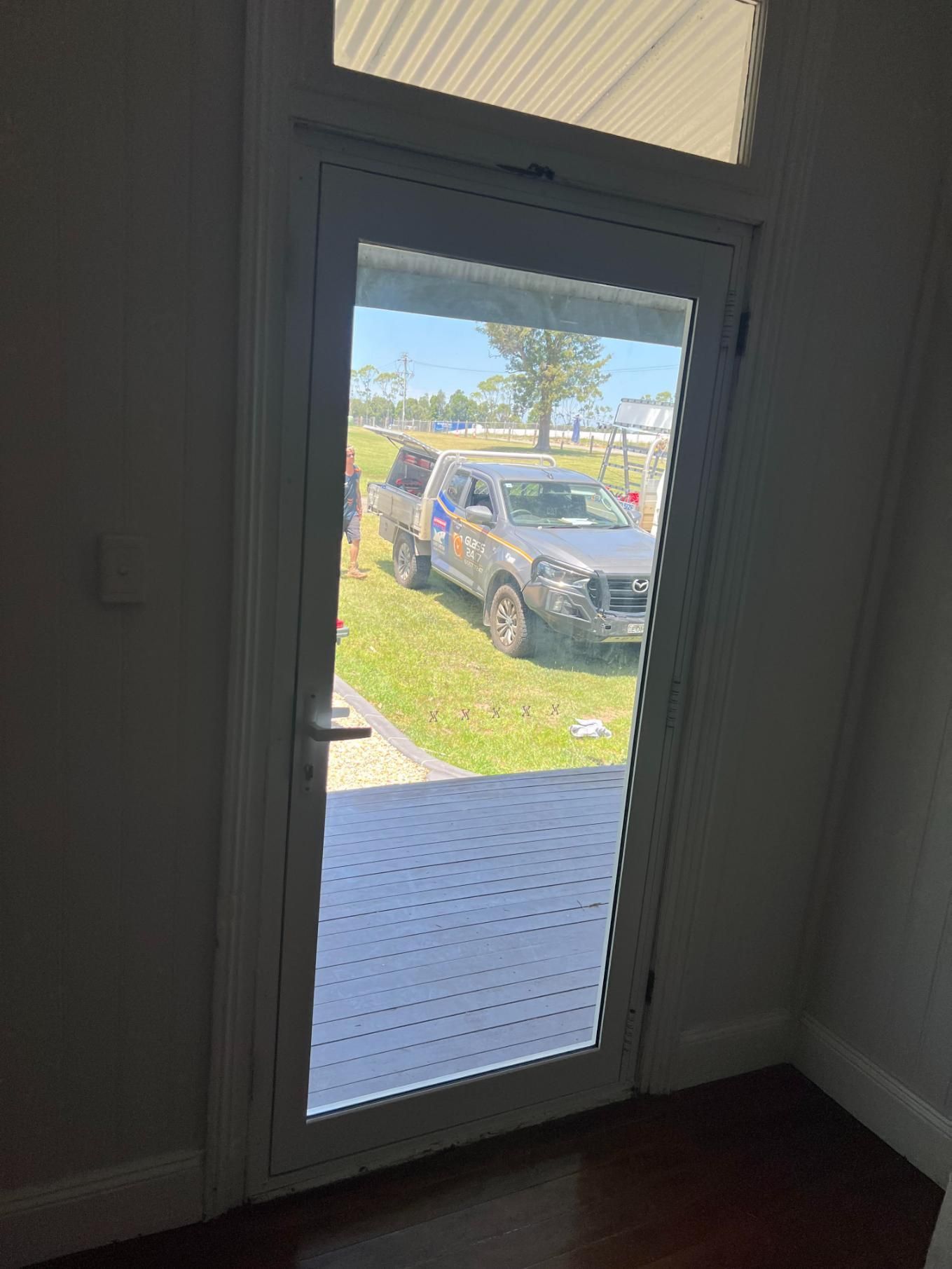 A Car Is Parked In The Grass In Front Of A Door — Glass 24/7 In Forster, NSW