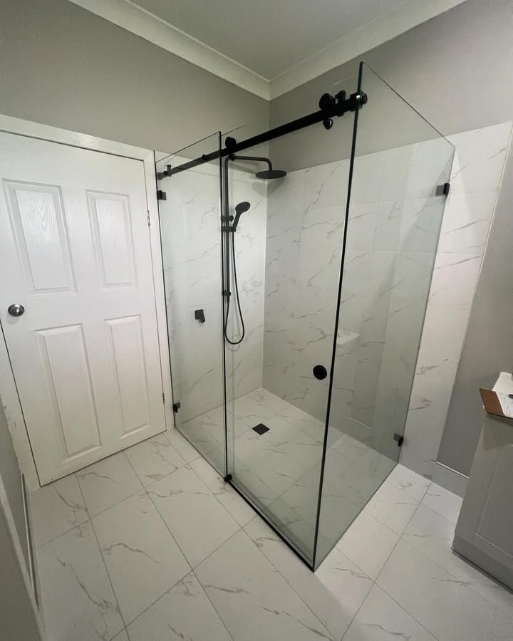 A Bathroom With A Sliding Glass Shower Door And A Shower Head — Glass 24/7 In Gloucester, NSW