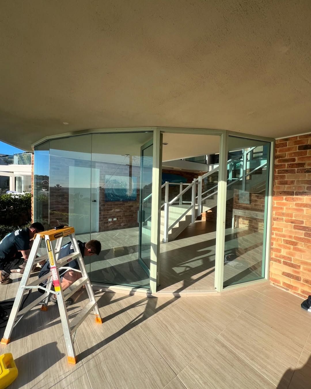 A Group Of People Are Working On A Glass Door — Glass 24/7 In Gloucester, NSW