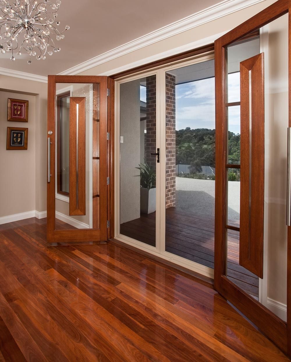 Wooden framed doors open to a patio; hardwood floor.