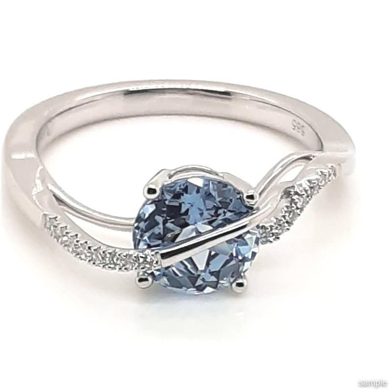 Silver ring with a blue gemstone and diamond accents.